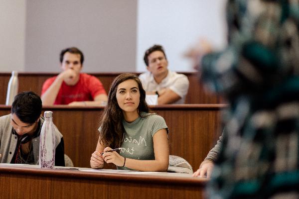 Chapman University students sit in a classroom, listening to a professor speak.